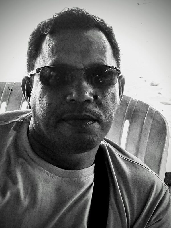 Black-and-white portrait of a jong builder or racer wearing sunglasses