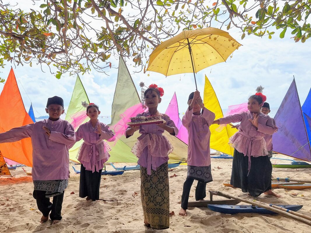 A group of women in traditional dress walking the beach with umbrellas, black and white