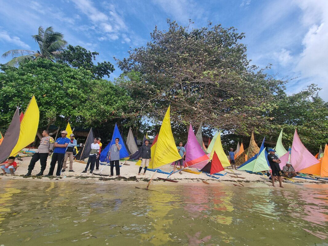 A gathering around a cluster of colorful jong sails, two views