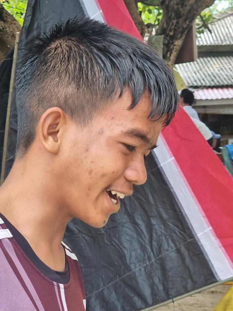 Side-profile portrait of a young man smiling