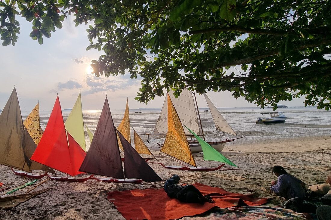 A row of jongs resting on the sand at low light