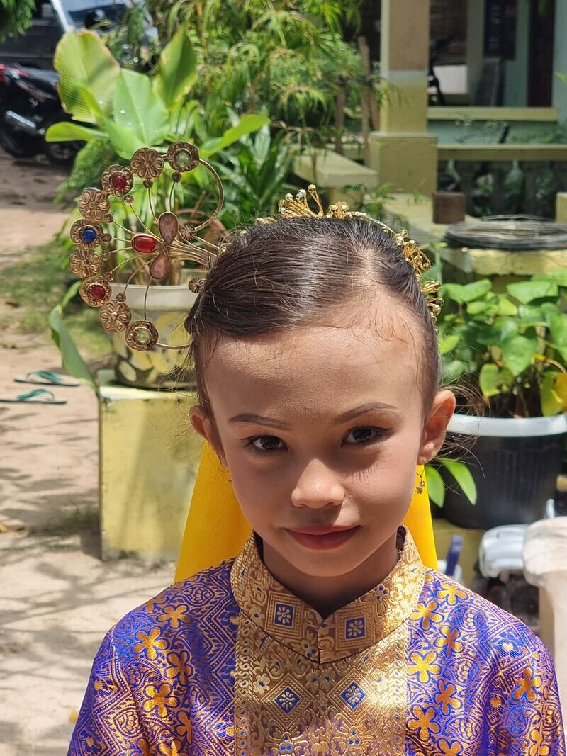 A girl in purple traditional dress standing in a garden