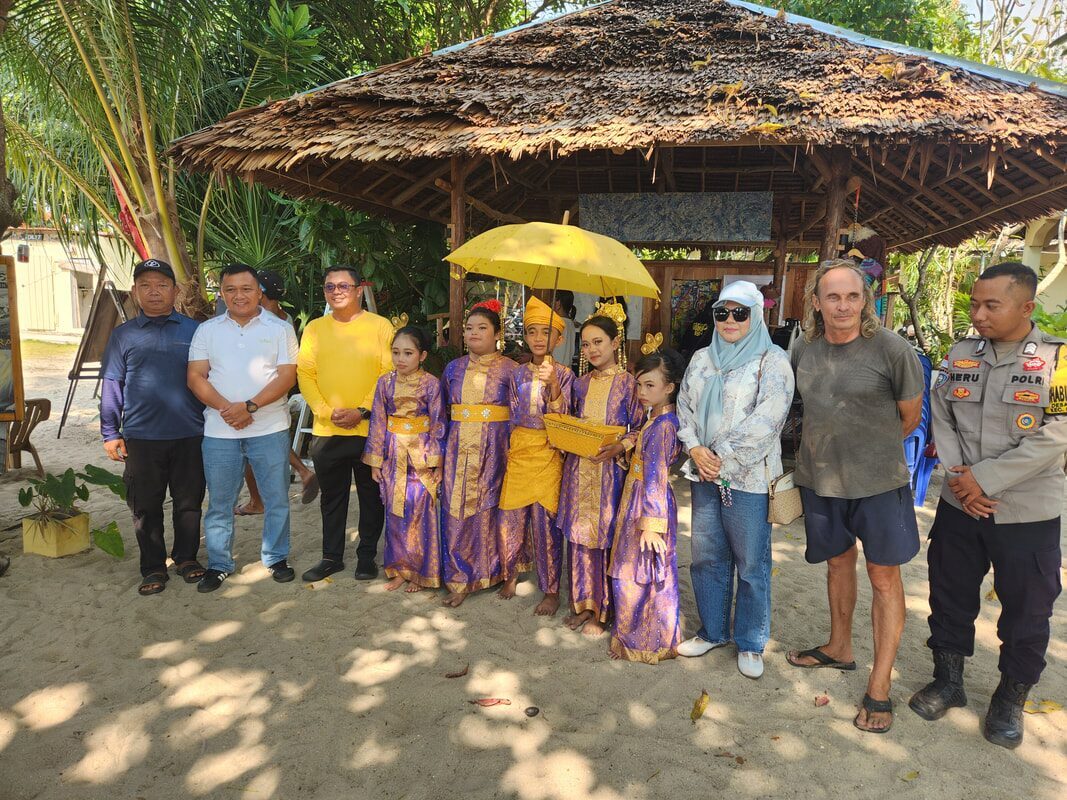 A man in traditional dress posing with a group under a canopy